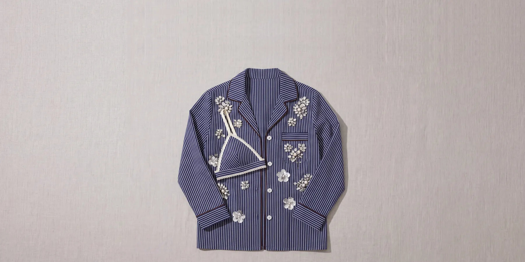 The crystal pinstripe shirt and picot bralette laid flat on linen